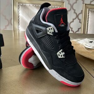 Jordan woman’s Black and Red Jordan 4 GS Sneakers